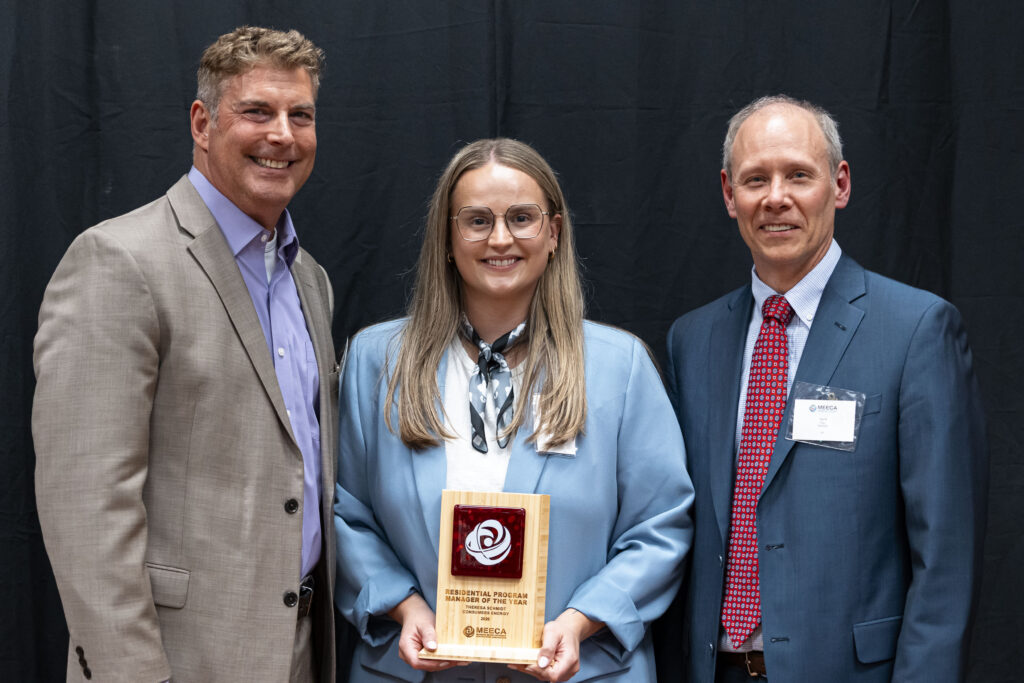 MEECA award recipient posing with her plaque and two presenters at the MEECA award ceremony.
