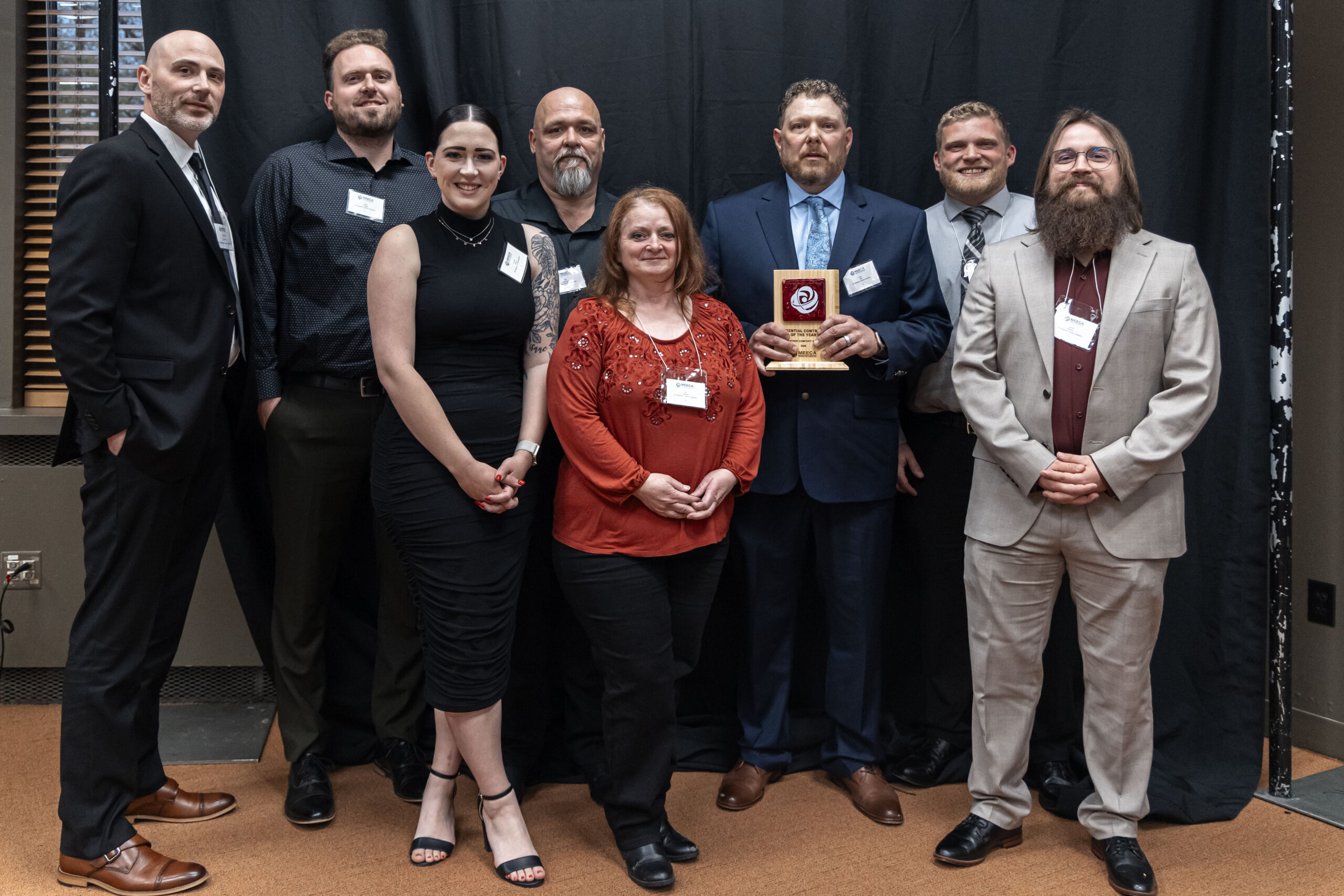 A MEECA member company team posing together with their award plaque at the MEECA award ceremony.